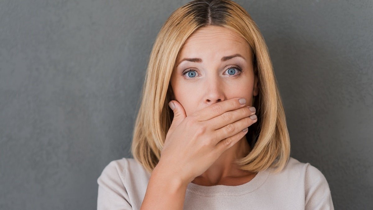 Woman hand over mouth